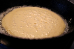 Pancake covered in bubbles, ready to flip.