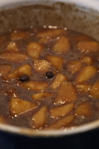 Pears brewing with spices, beans and syrup.